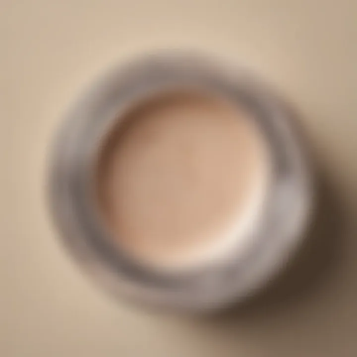 Close-up of a cream eyeshadow container with a brush