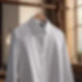 Elegant white cotton button down shirt displayed on a wooden hanger