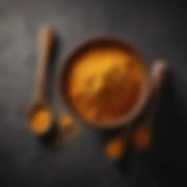 A close-up of turmeric powder in a bowl with a wooden spoon